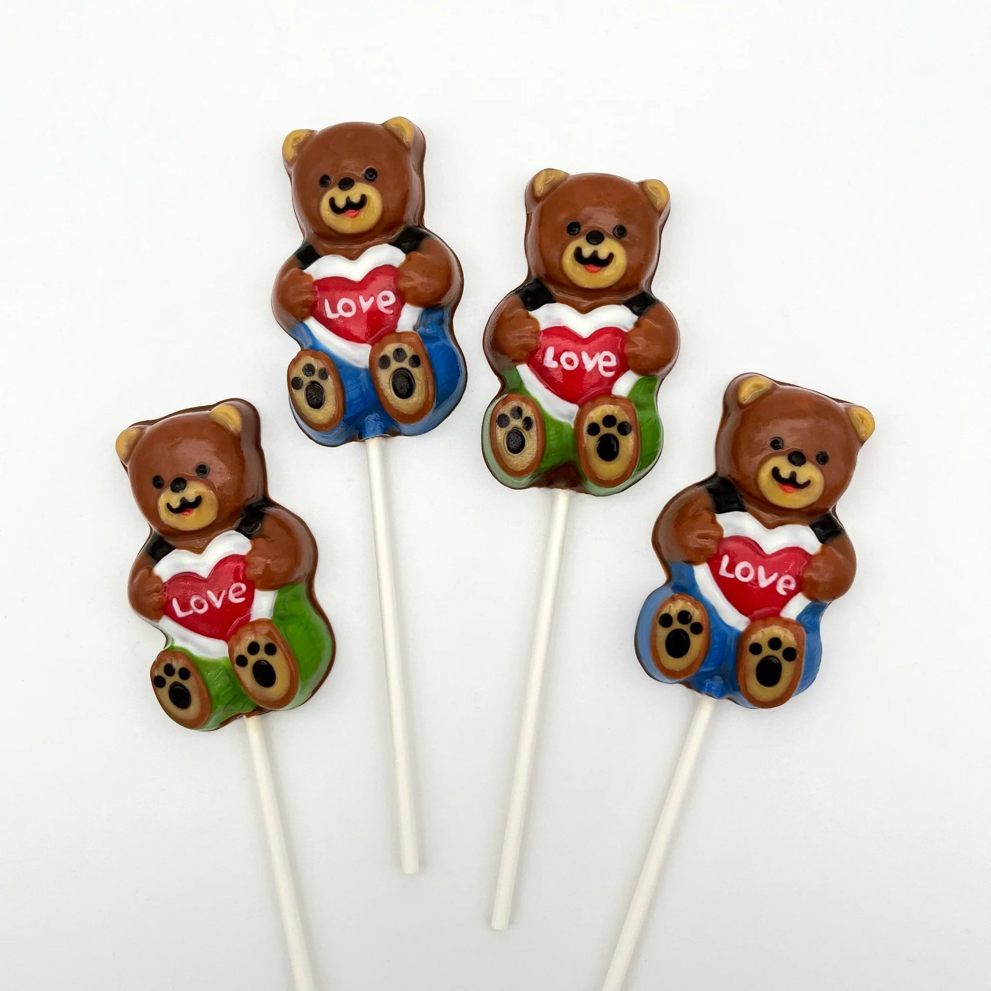 Adorable brown chocolate bear sucker with green or blue pants and suspenders, holding a heart-shaped sign saying LOVE.