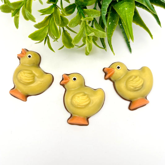 Cute little yellow and orange chicks cheeping, all made from chocolate.