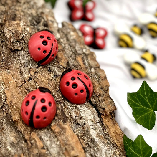 Red ladybug with black spots and head, all made of chocolate.
