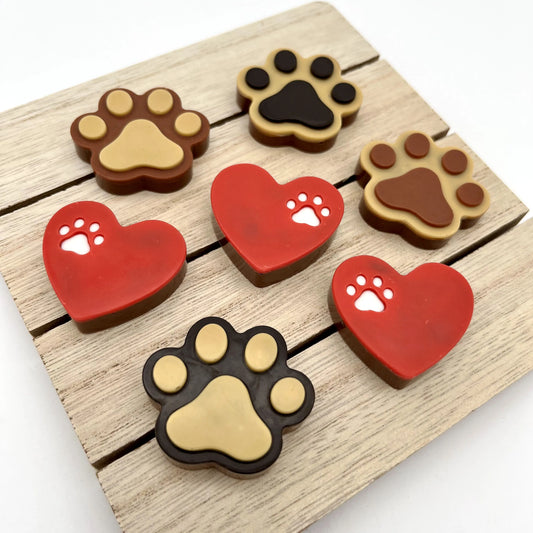 Red heart with a little white paw print on the top part, along with paw prints in two-toned brown. All made from chocolate.