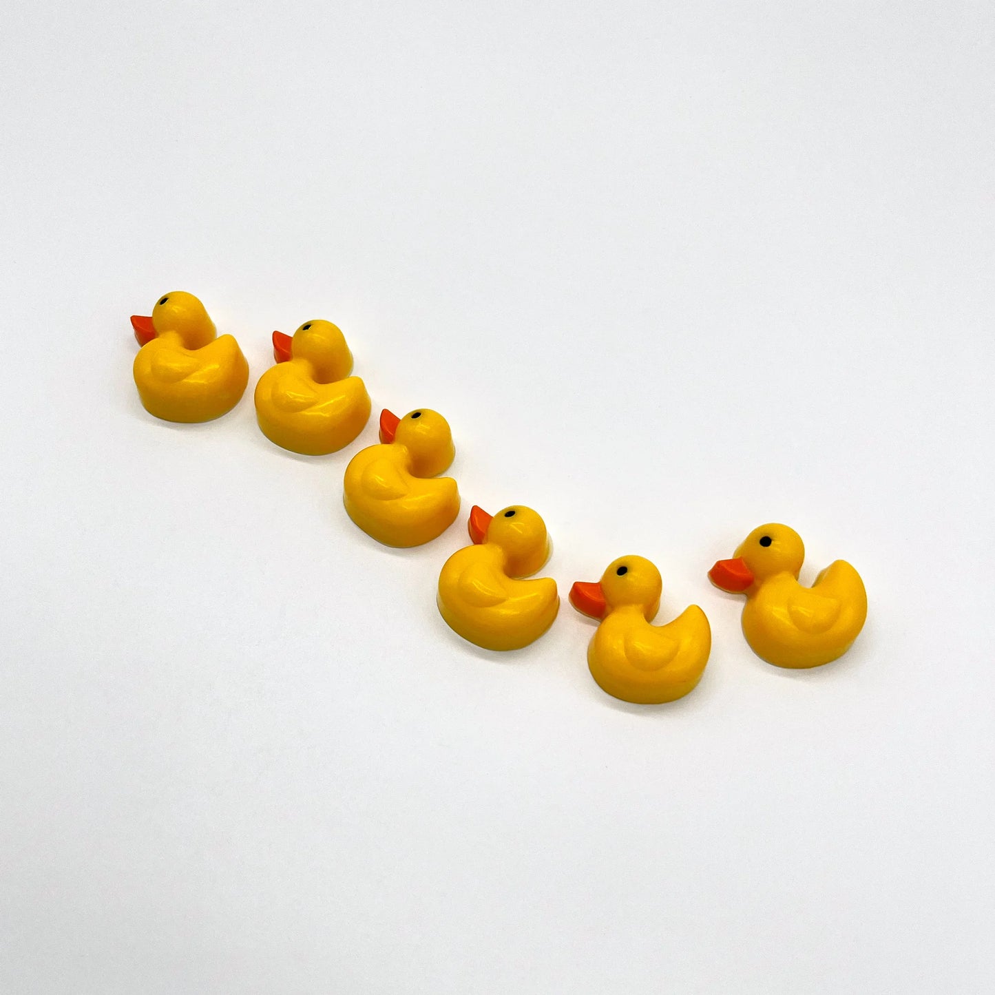 Row of chocolate yellow baby duckies with orange beaks and black eyes.