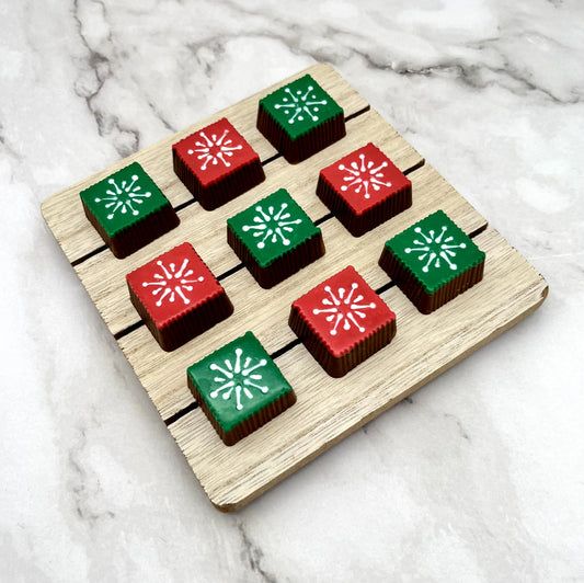 Chocolate squares decorated in red and green, topped with a delicate white snowflake design.