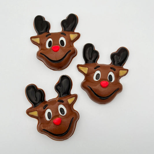 Three reindeer-shaped chocolates with brown bodies, black antlers, red noses, animated eyes, all on a white background.