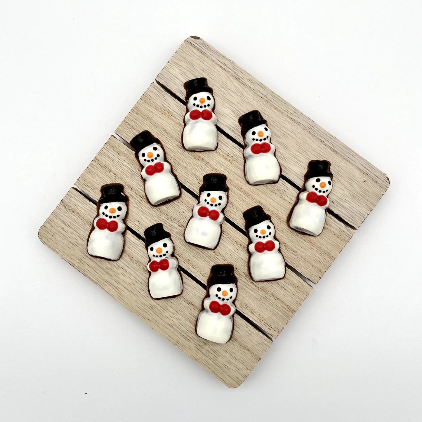 Adorable chocolate snowmen with black top hats and button smiles, orange noses and red hand warmers.