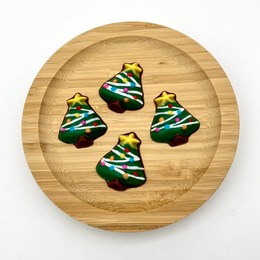 Small chocolate Christmas trees, decorated in multi-colour dots for lights and white draping, topped with a yellow star.
