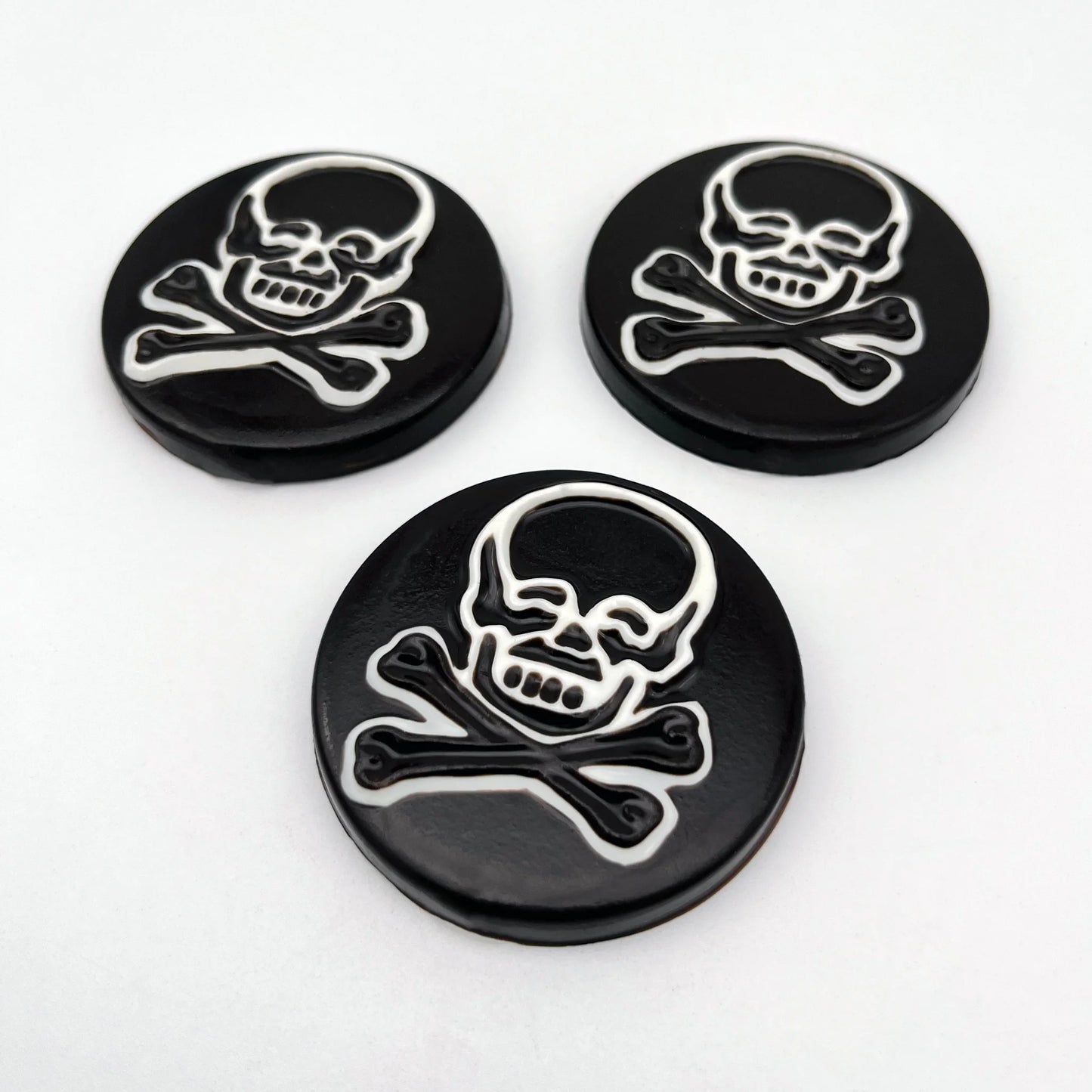 Large striking skull and crossbones chocolate medallions, with a bold black-and-white contrast.