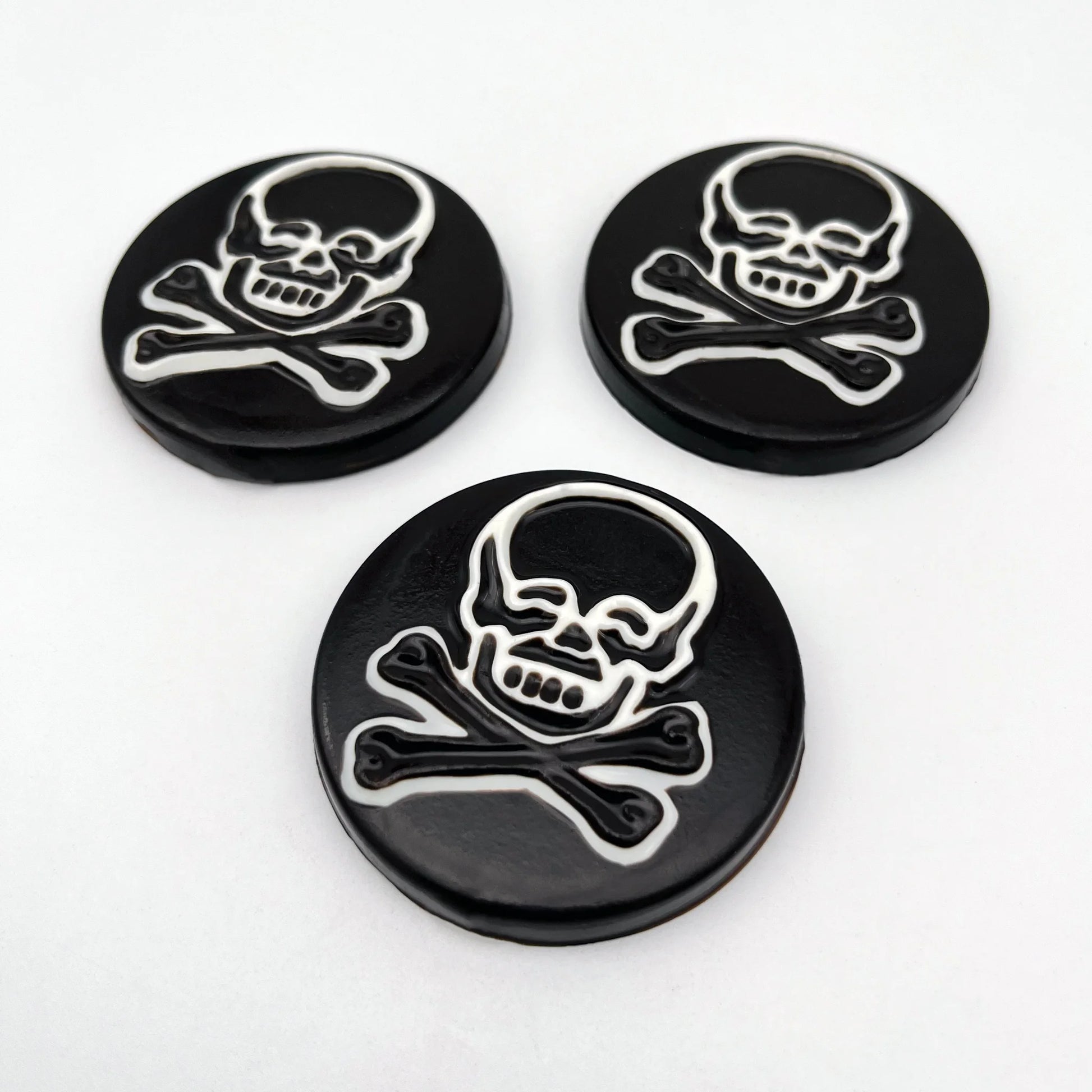 Large striking skull and crossbones chocolate medallions, with a bold black-and-white contrast.