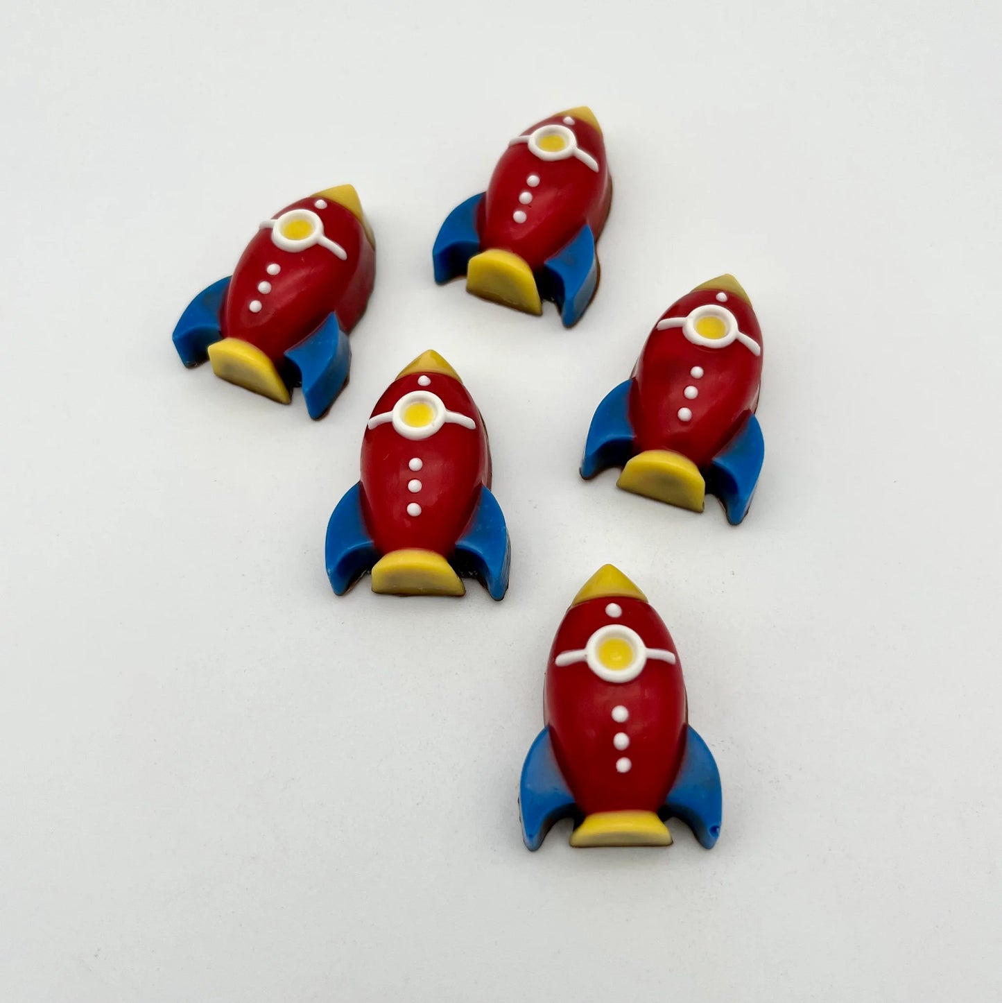 Cute cartoon-style chocolate rockets, coloured in red, blue, yellow and white.
