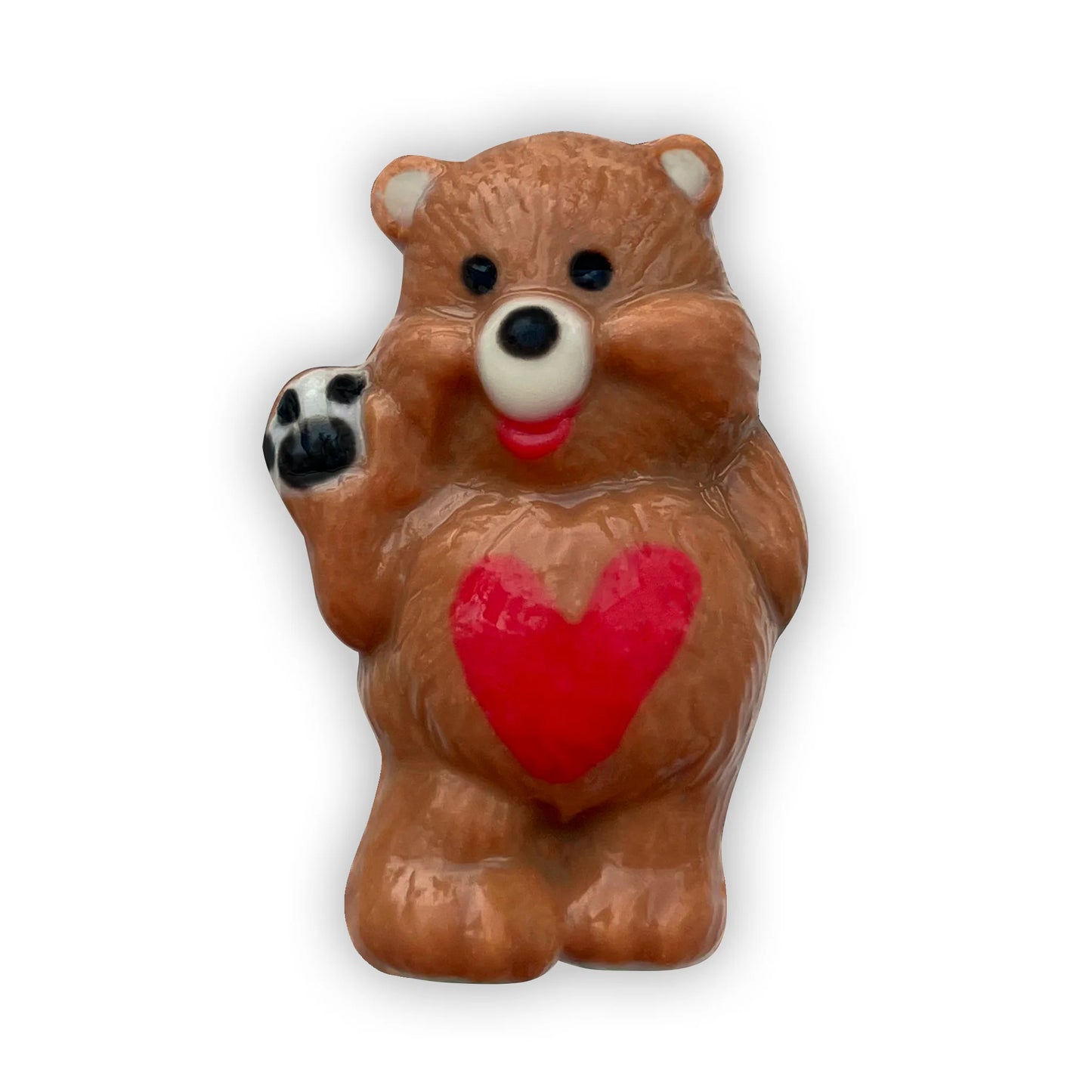 Chocolate bear waving shyly, decorated in brown and beige, with a red heart on its tummy and black paws. 
