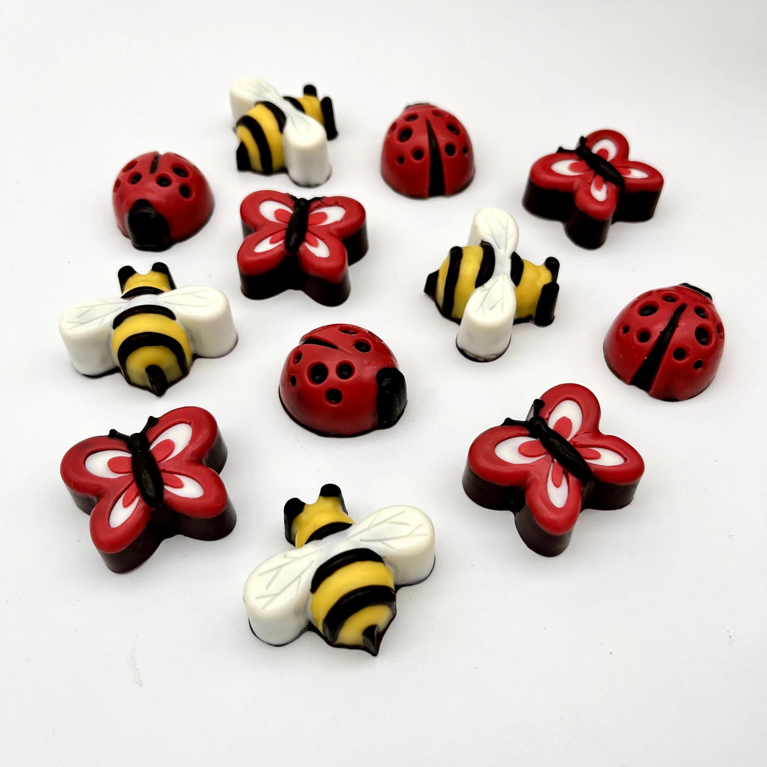 Realistic looking chocolates of red and black ladybugs, yellow and black striped bees, and red, black and white butterflies.