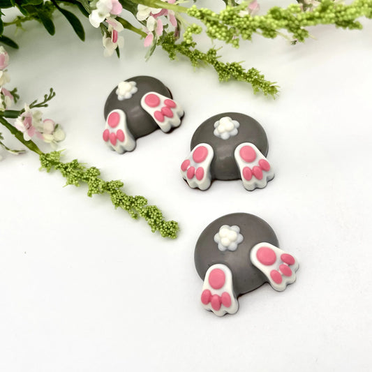 Three fun grey-coloured chocolate baby bunny butts with little pink toes and white tails.