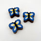 Chocolate butterflies coloured with blue, yellow and white wings, black bodies and antennas.
