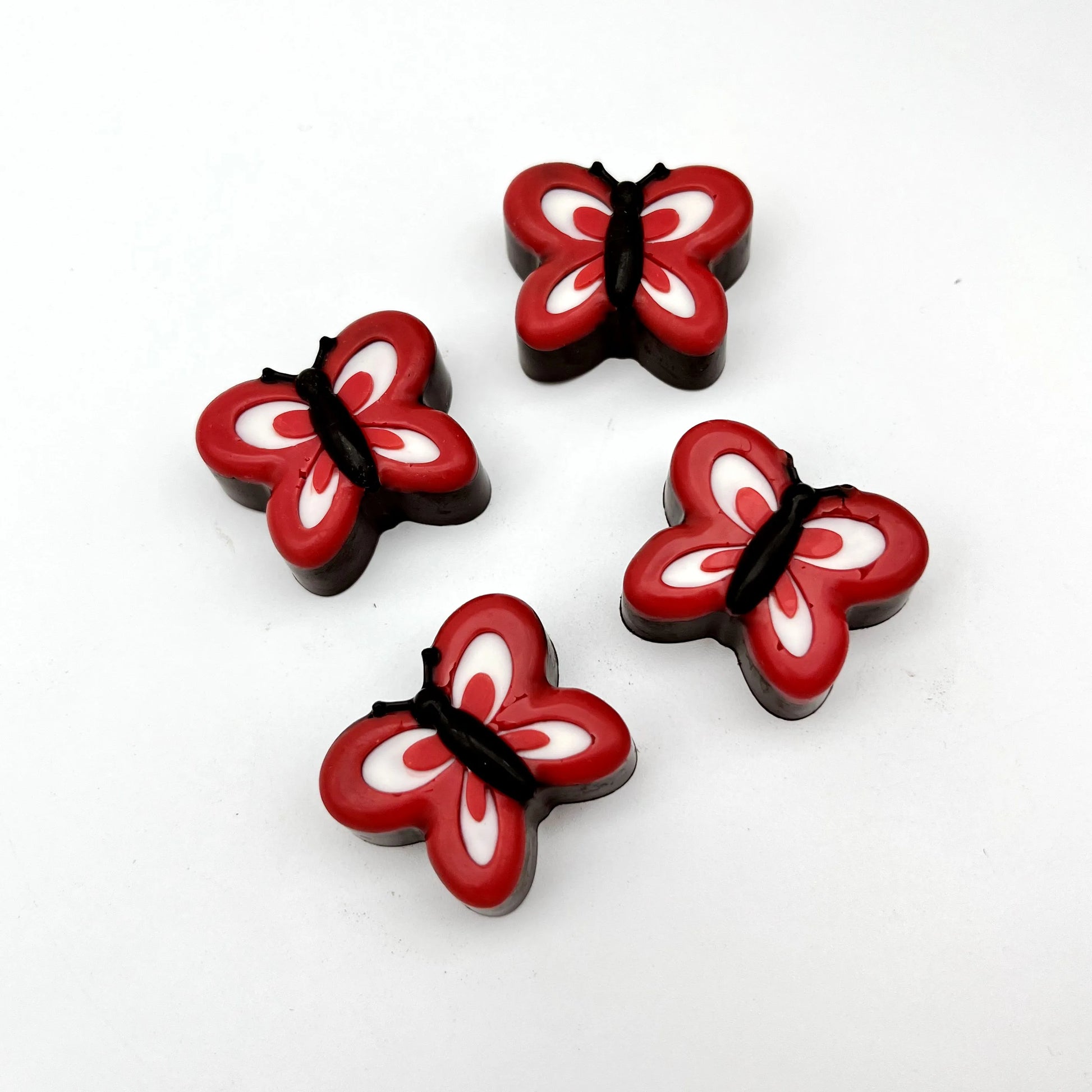 Chocolate butterflies coloured with red and white wings, black bodies and antennas.
