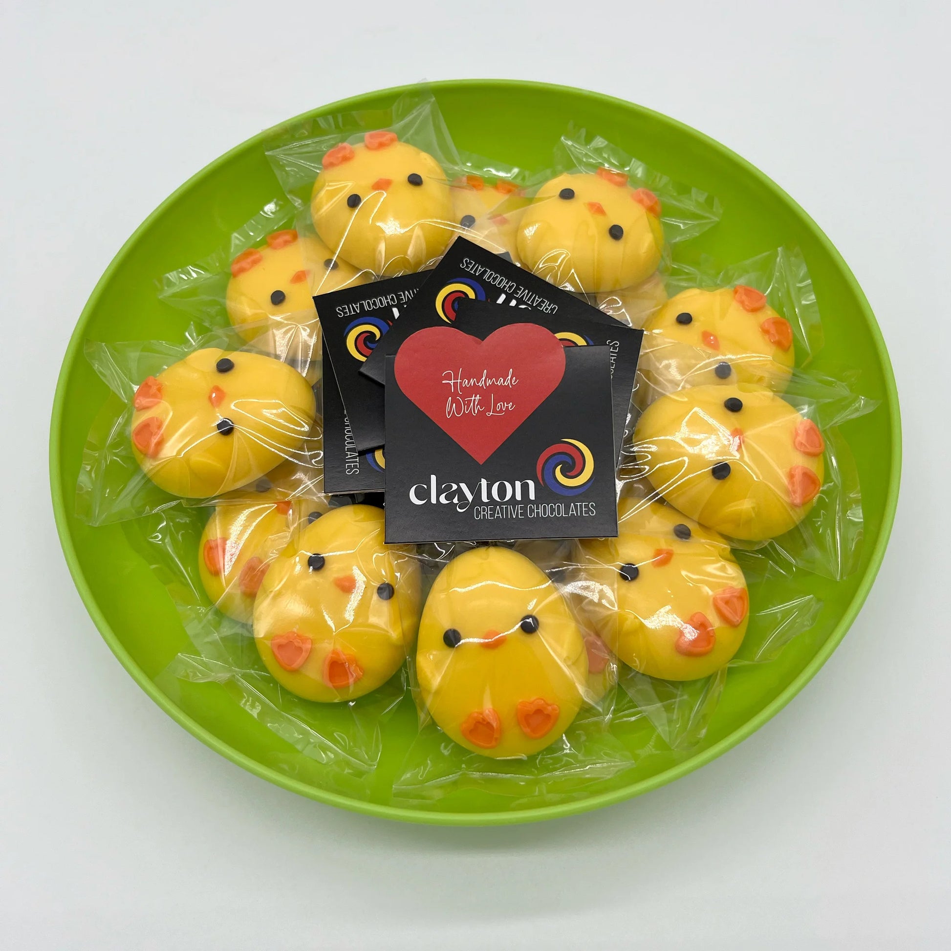 Oval-shaped yellow and orange chicks, filled with white chocolate. Presented in Clayton Creative Chocolates packaging.