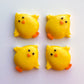 Adorable chubby yellow chicks made from chocolate, with smiling eyes, little orange feet and bills, all flapping their wings.