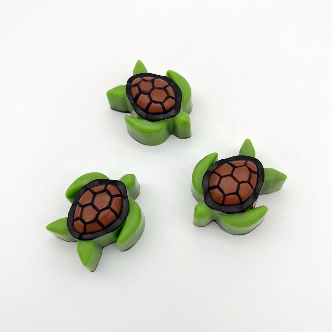 Chocolate turtles that look like they are swimming, coloured in green with a brown and black shell.