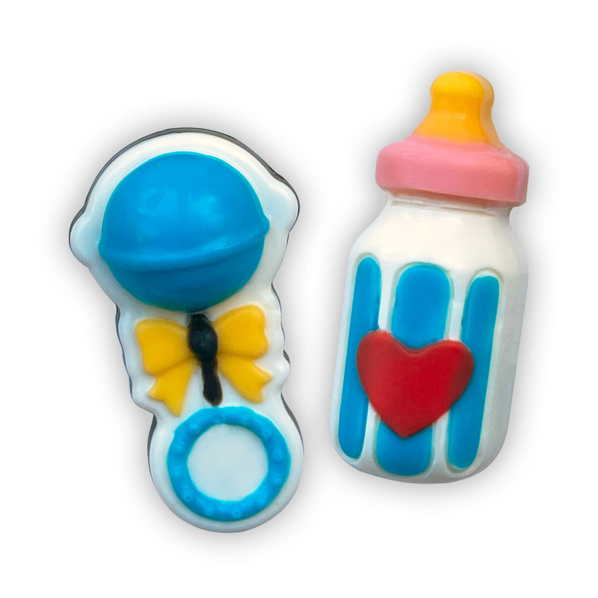 Hand-painted chocolates of blue-themed baby rattle with yellow ribbon, and milk bottle with red heart, yellow and pink top.