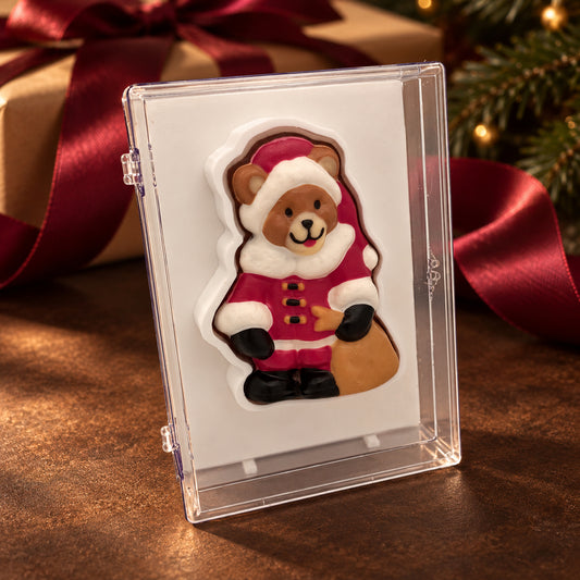 Chocolate teddy bear dressed in a red Santa suit and hat in a clear acrylic gift box.