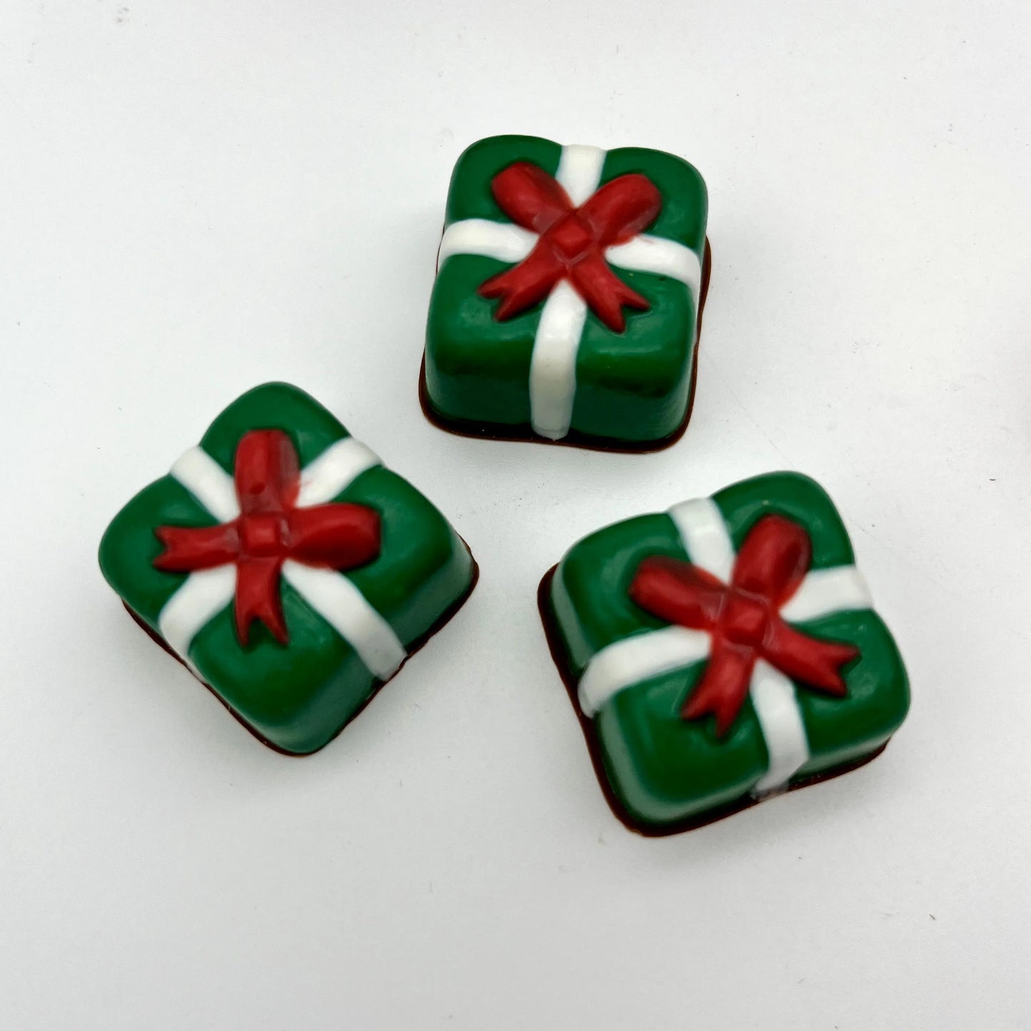 Delightful square Christmas presents made from chocolate; green with white ribbon and red bow.