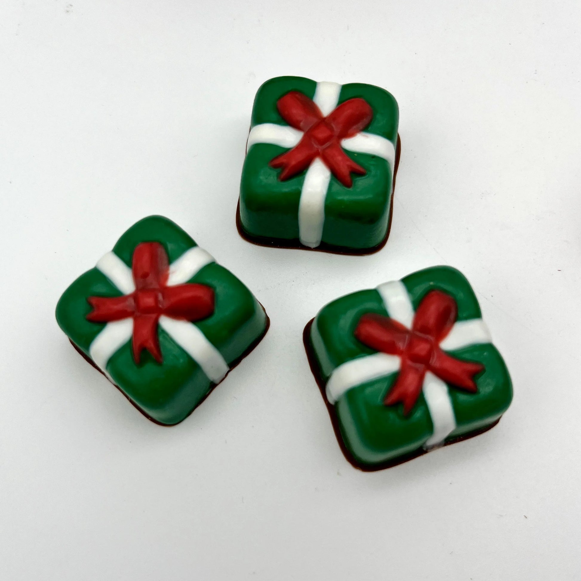 Delightful square Christmas presents made from chocolate; green with white ribbon and red bow.