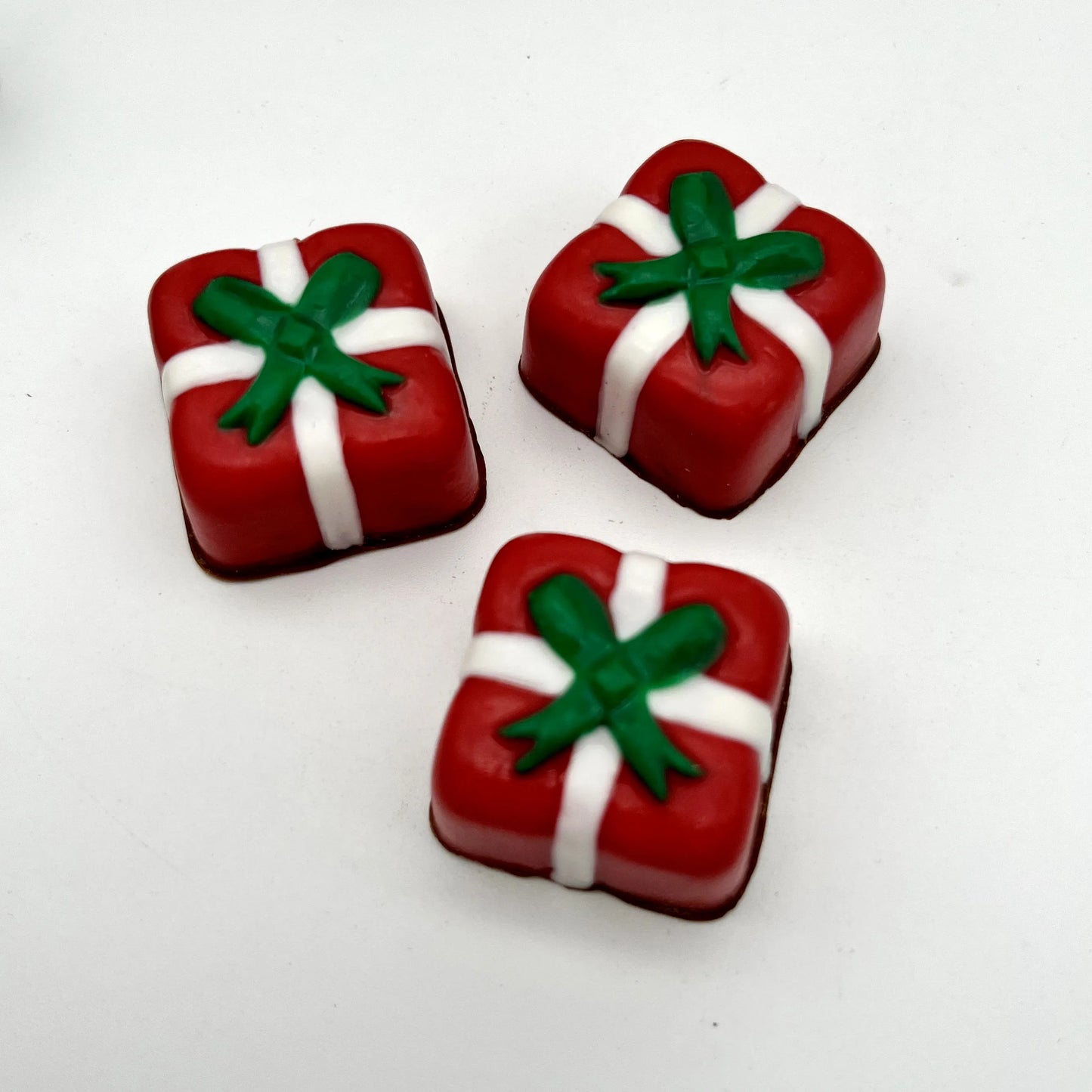 Delightful square Christmas presents made from chocolate; red with white ribbon and green bow.