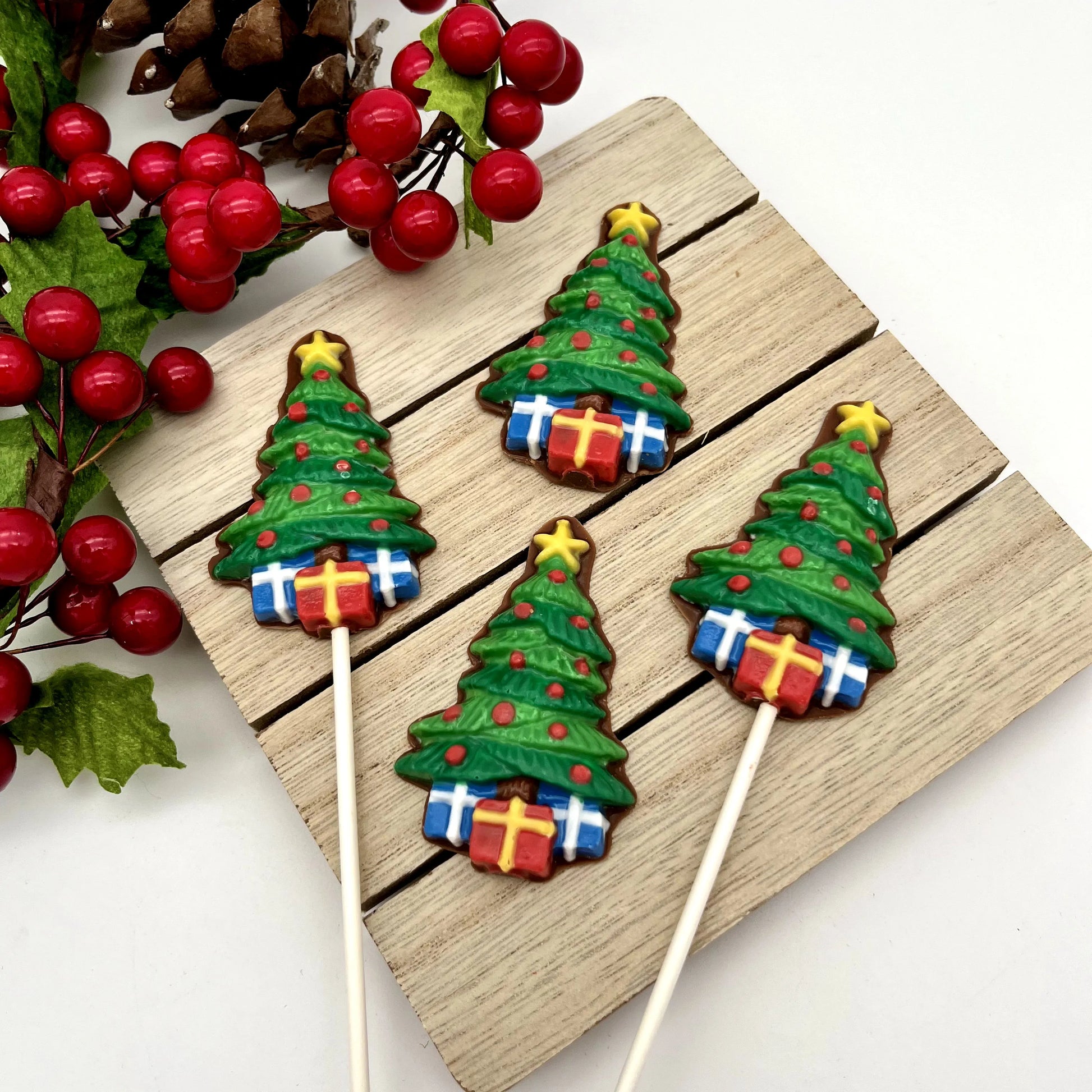 Chocolate Christmas trees with colourful red "lights" and presents underneath, topped with a yellow star.
