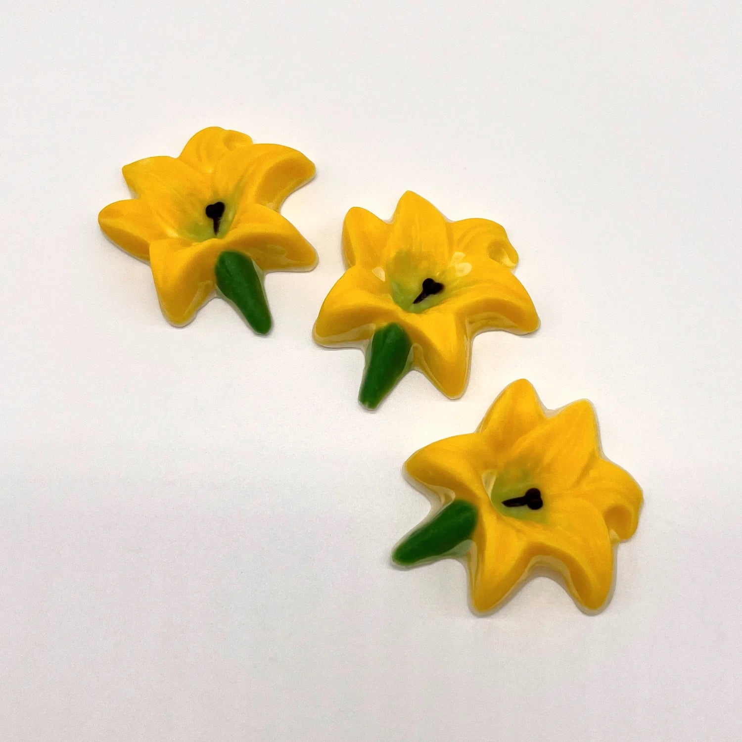 Chocolate lily flower in classic yellow with a green centre and stalk, and a black stamen.
