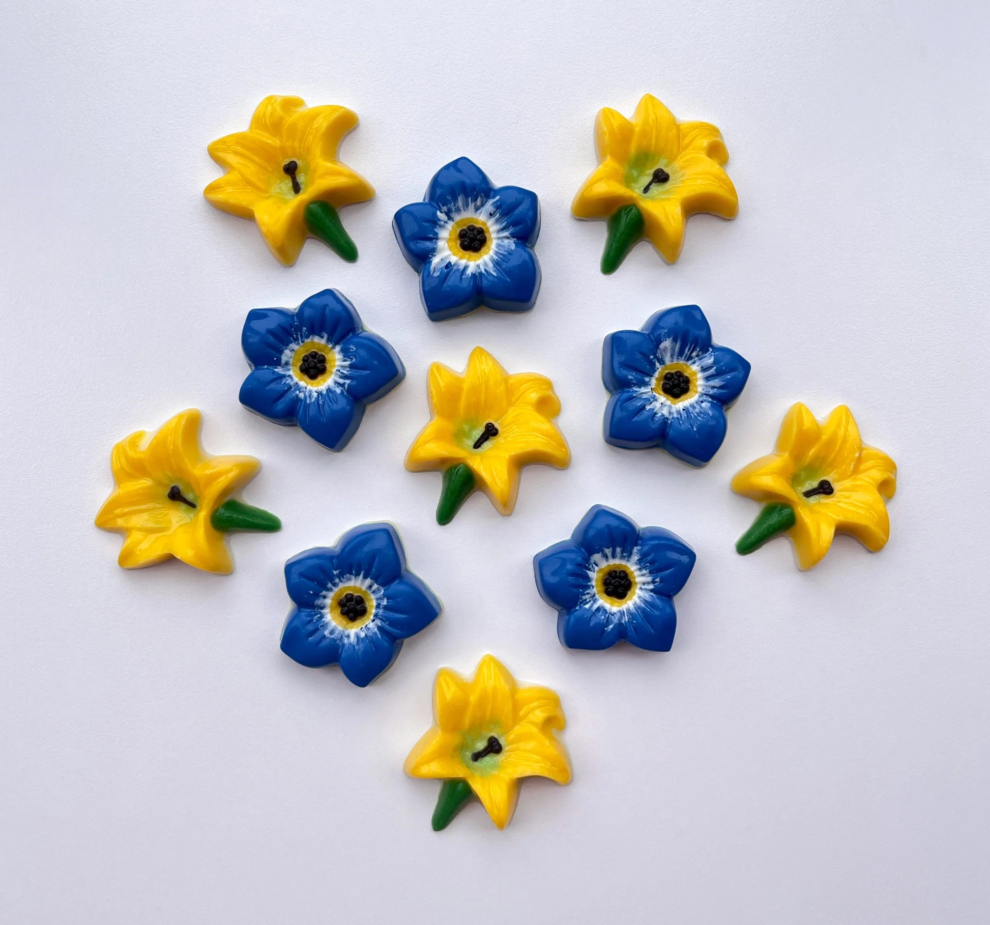 Lily flower in classic yellow, green and black. Pictured with blue forget-me-not flowers. All made from chocolate.