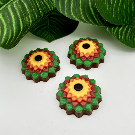 Vibrantly coloured zinnia-style flowers in yellow, orange, red and green, made from chocolate.