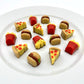 Realistic-looking brightly-coloured pizza slices, burgers, and fries in a box, arranged on a plate. All made from chocolate.
