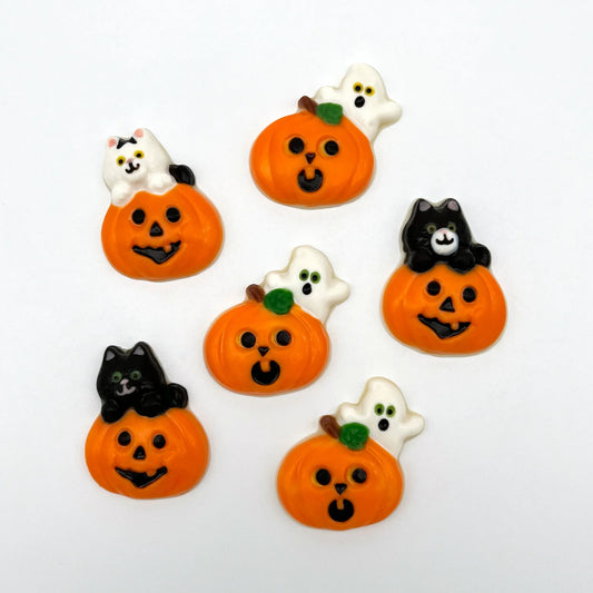 Orange pumpkins with carved faces, some with ghosts, some with black or white cats on top.