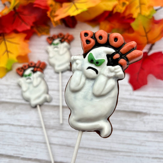 Angry-looking white ghost chocolate suckers, with green and black eyes, and the word Boo!! over the top in orange and black. 