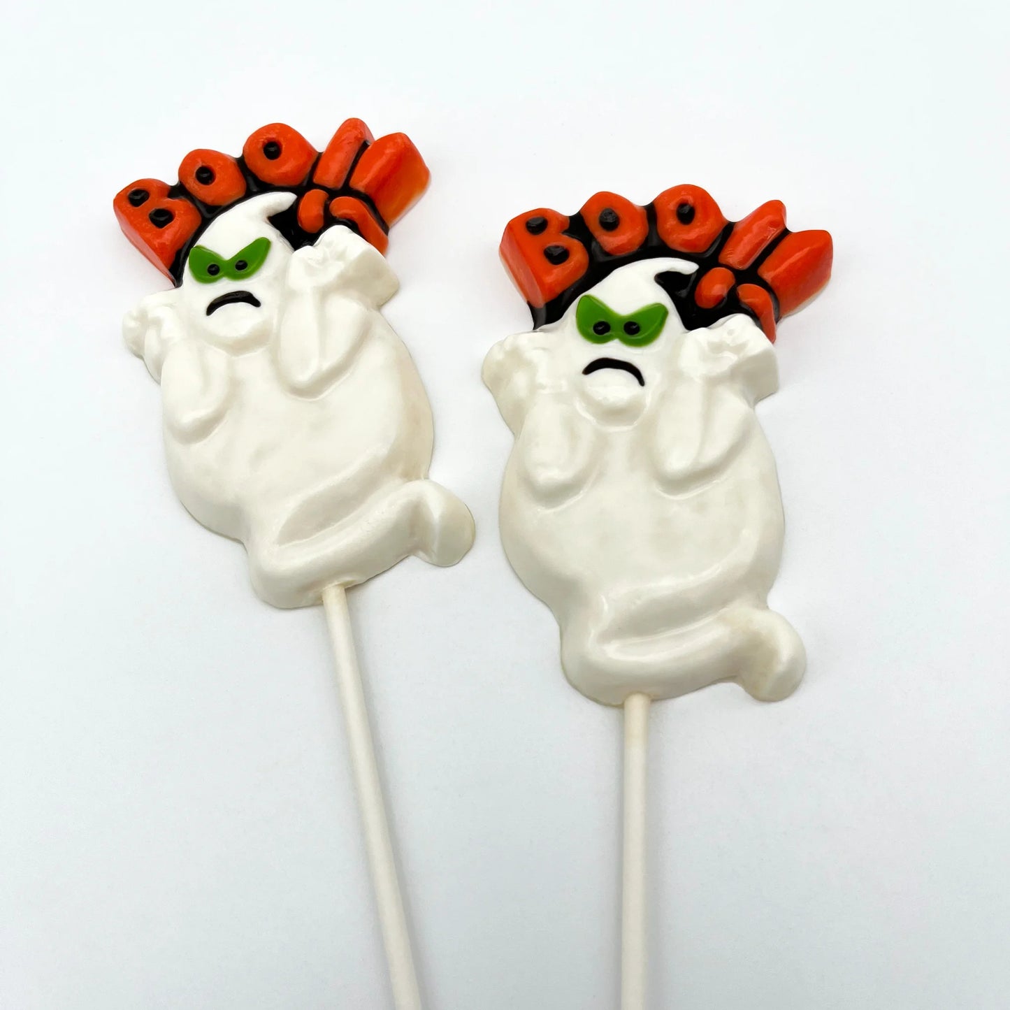 Angry-looking white ghost chocolate suckers, with green and black eyes, and the word Boo!! over the top in orange and black. 