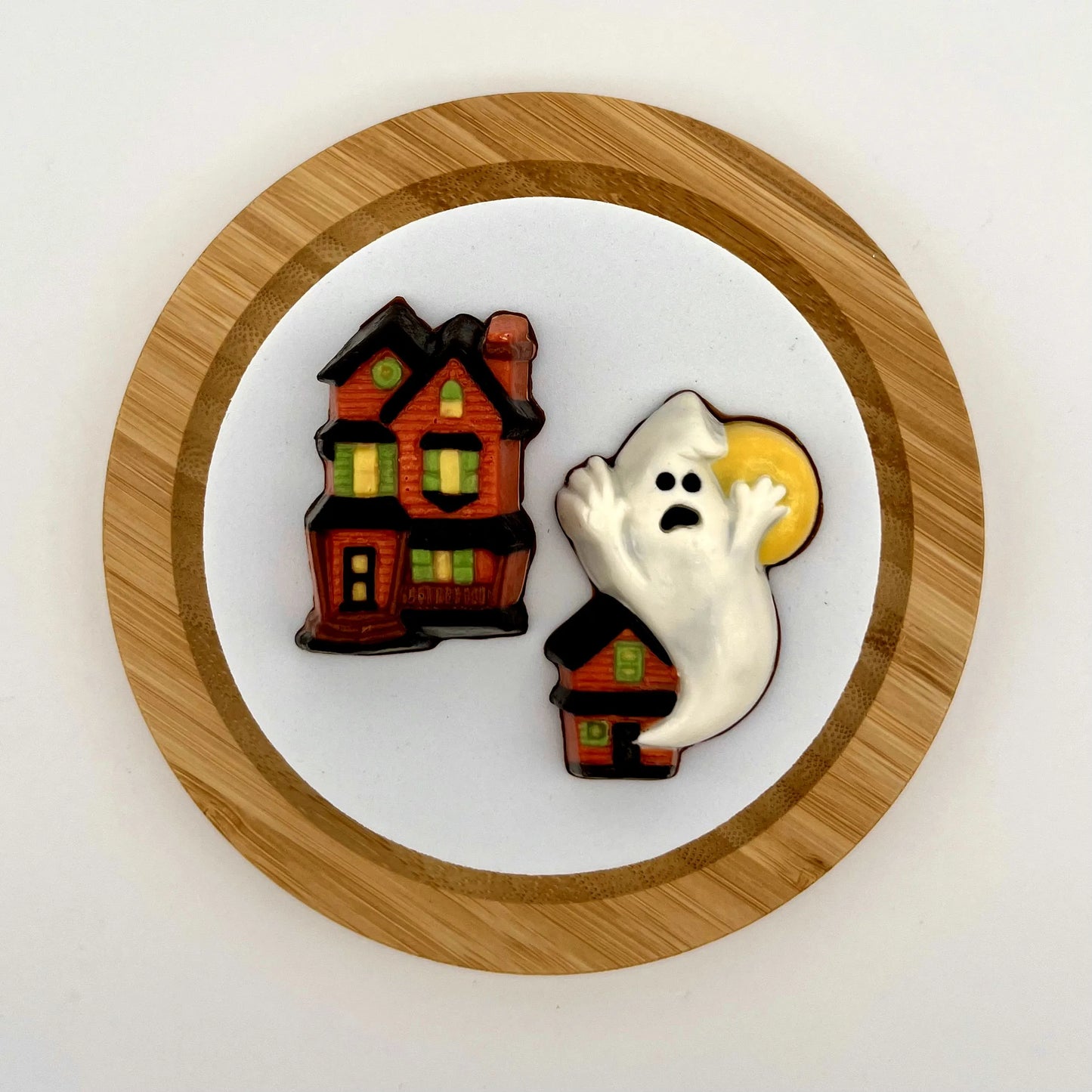 Haunted house and haunted house with a ghost and full moon, both made from chocolate.