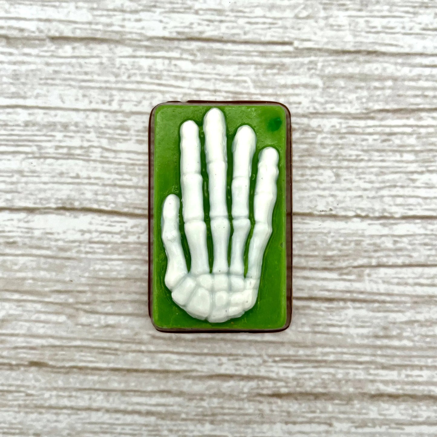 White skeleton hand on a green coloured rectangle, made from chocolate. 