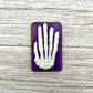 White skeleton hand on a purple coloured rectangle, made from chocolate. 