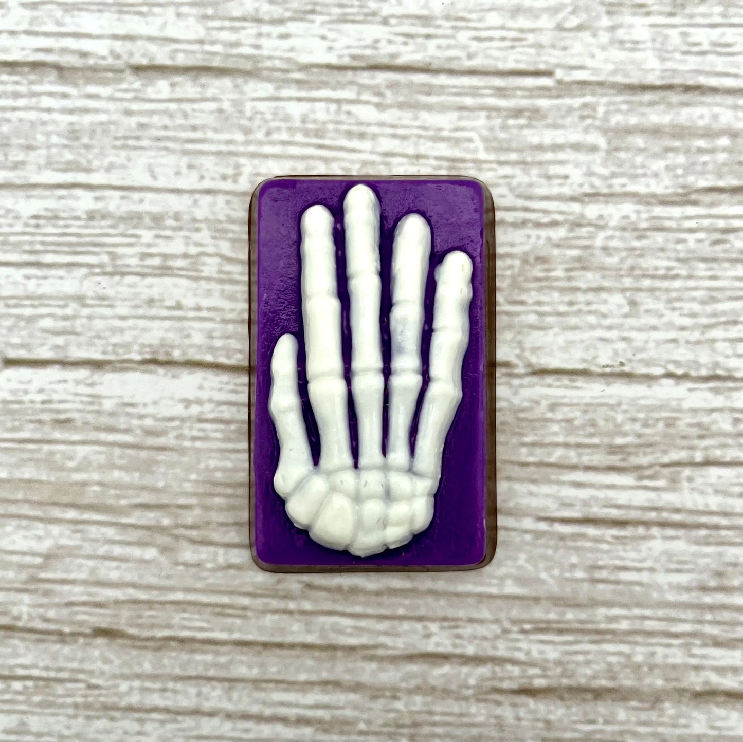 White skeleton hand on a purple coloured rectangle, made from chocolate. 