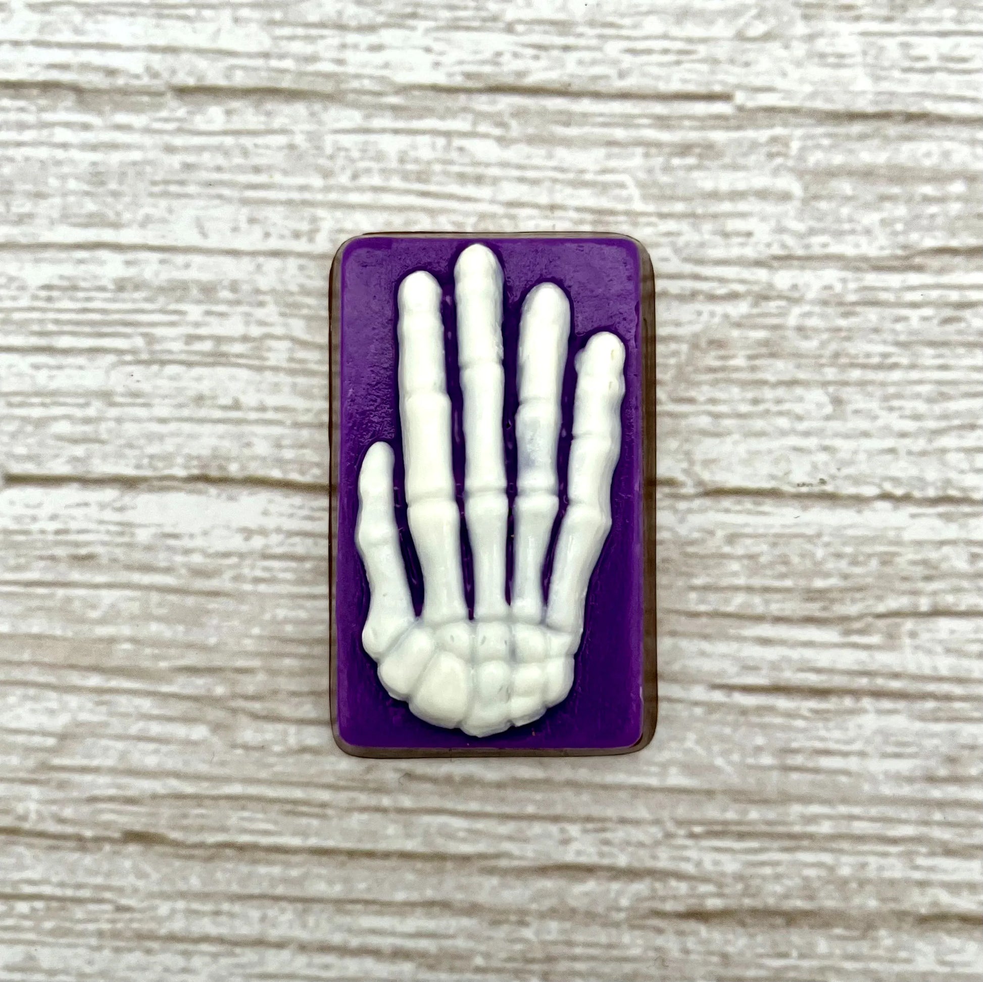 White skeleton hand on a purple coloured rectangle, made from chocolate. 