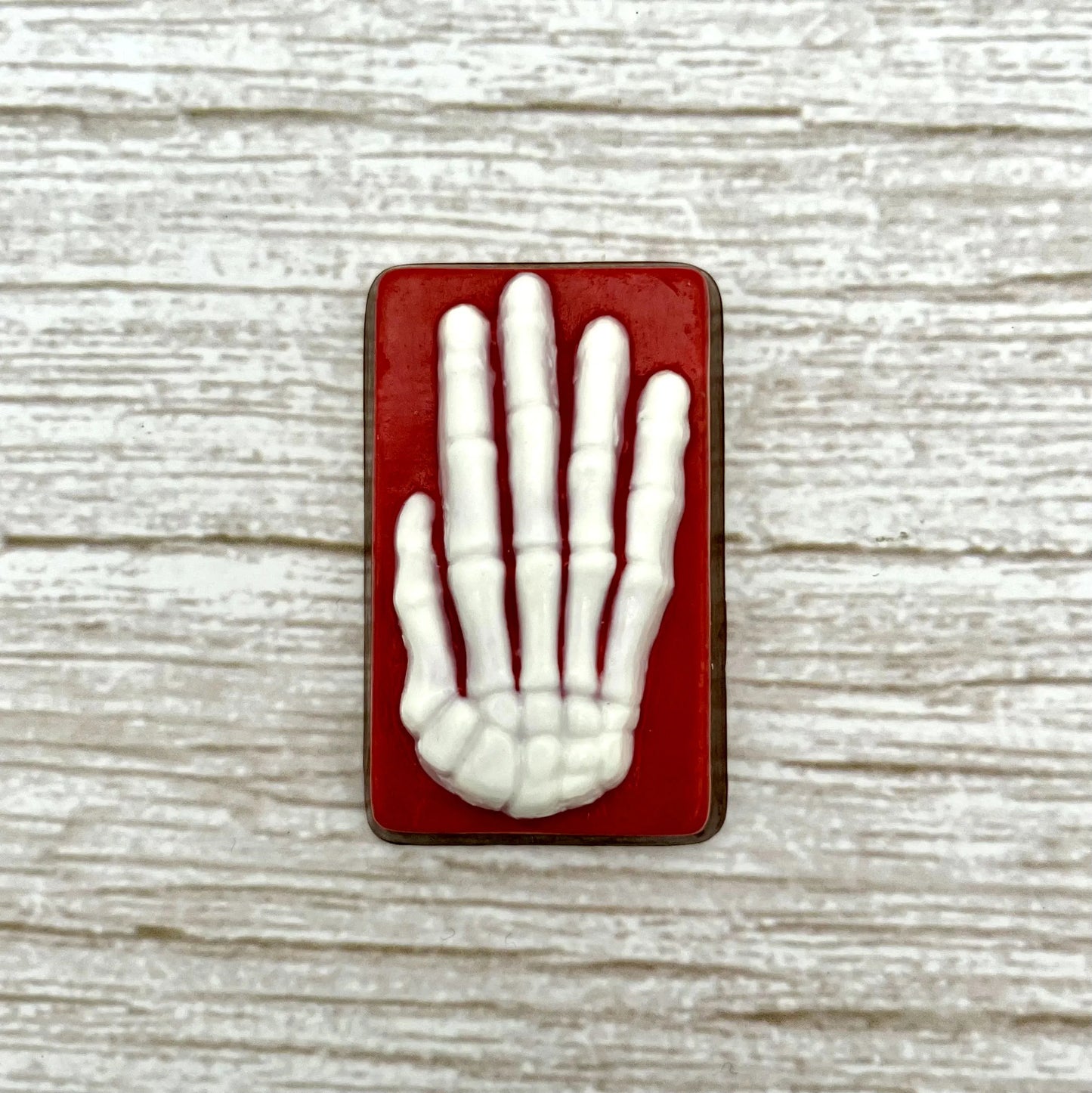 White skeleton hand on a red coloured rectangle, made from chocolate. 