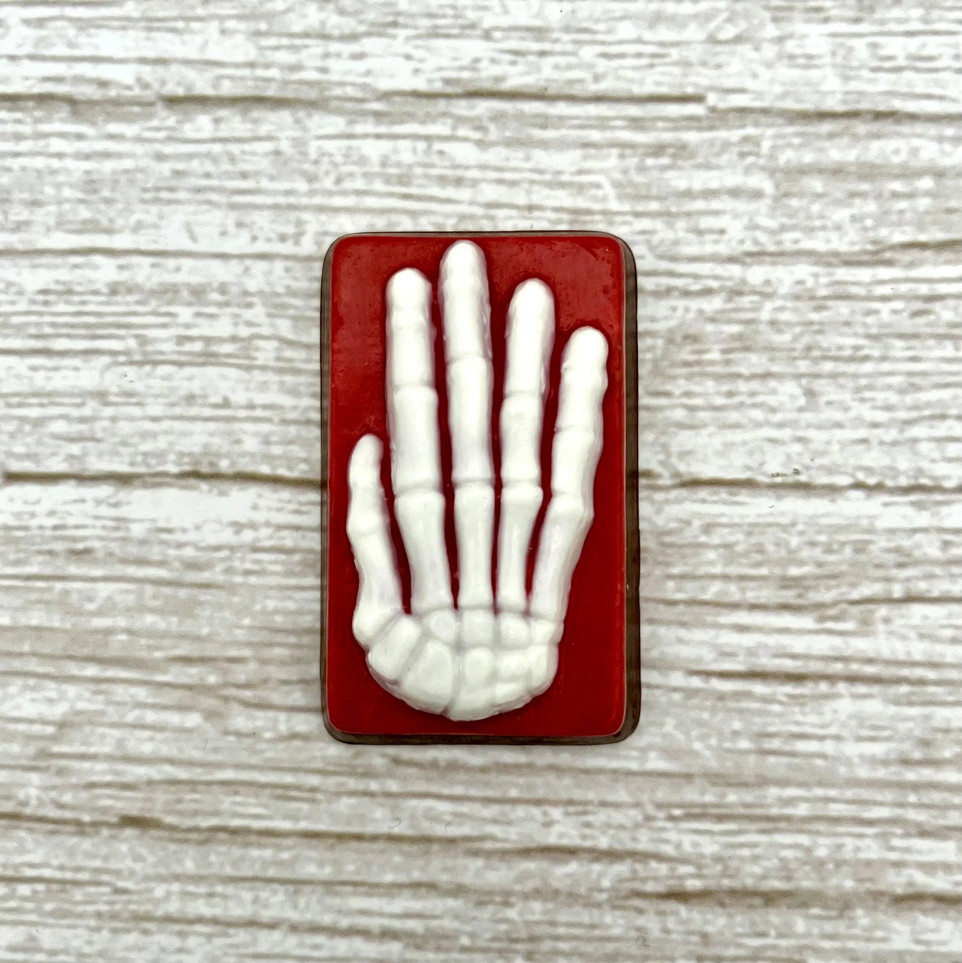 White skeleton hand on a red coloured rectangle, made from chocolate. 