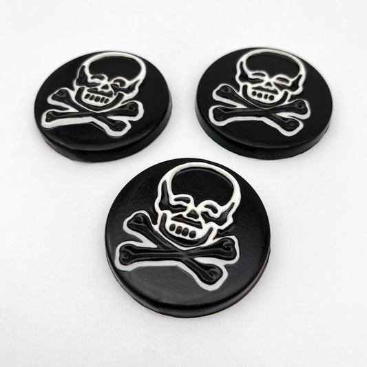 Large striking skull and crossbones chocolate medallions, with a bold black-and-white contrast.