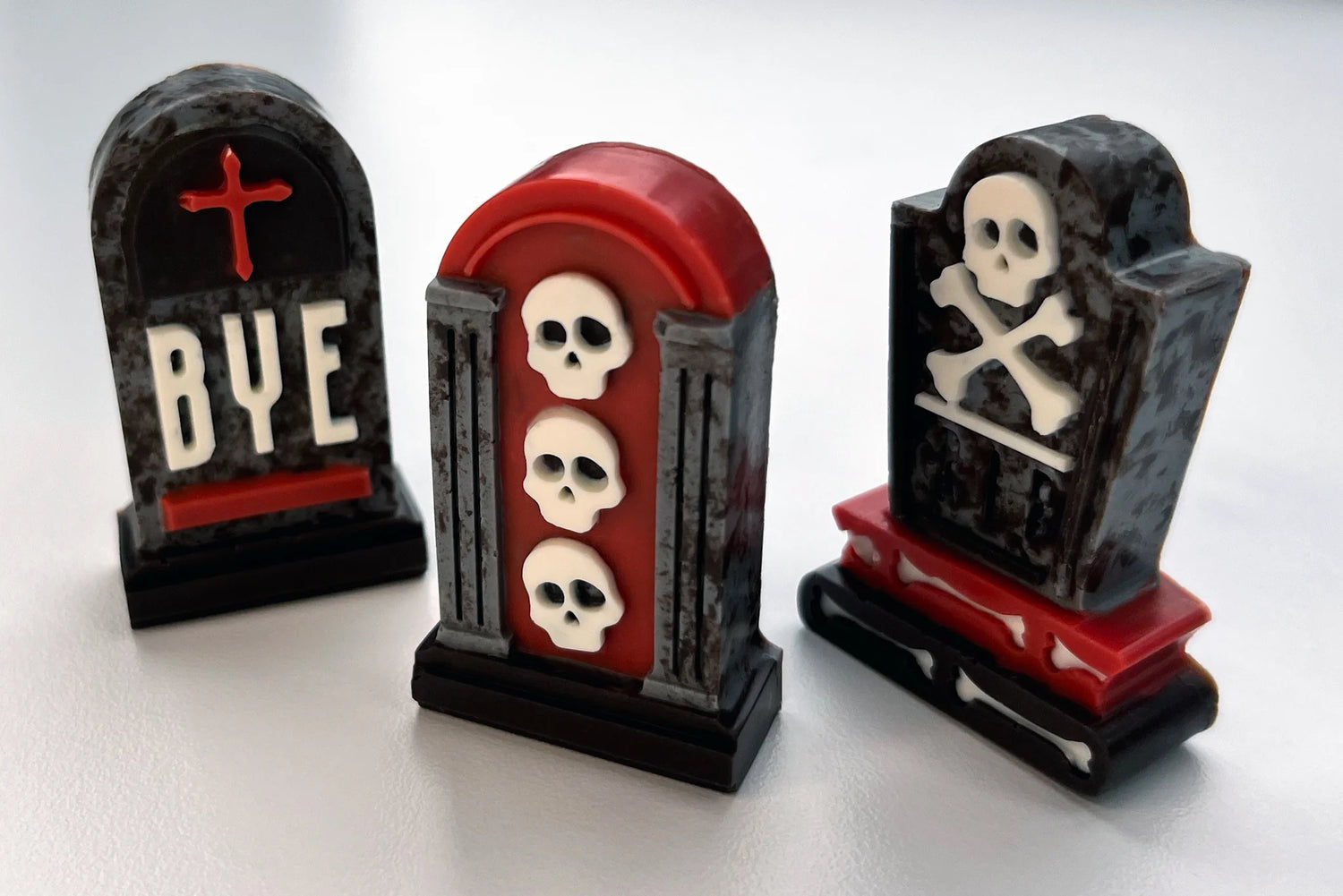 Set of chocolate Halloween-themed tombstones with skulls and crossbones, coloured in black, red and grey.