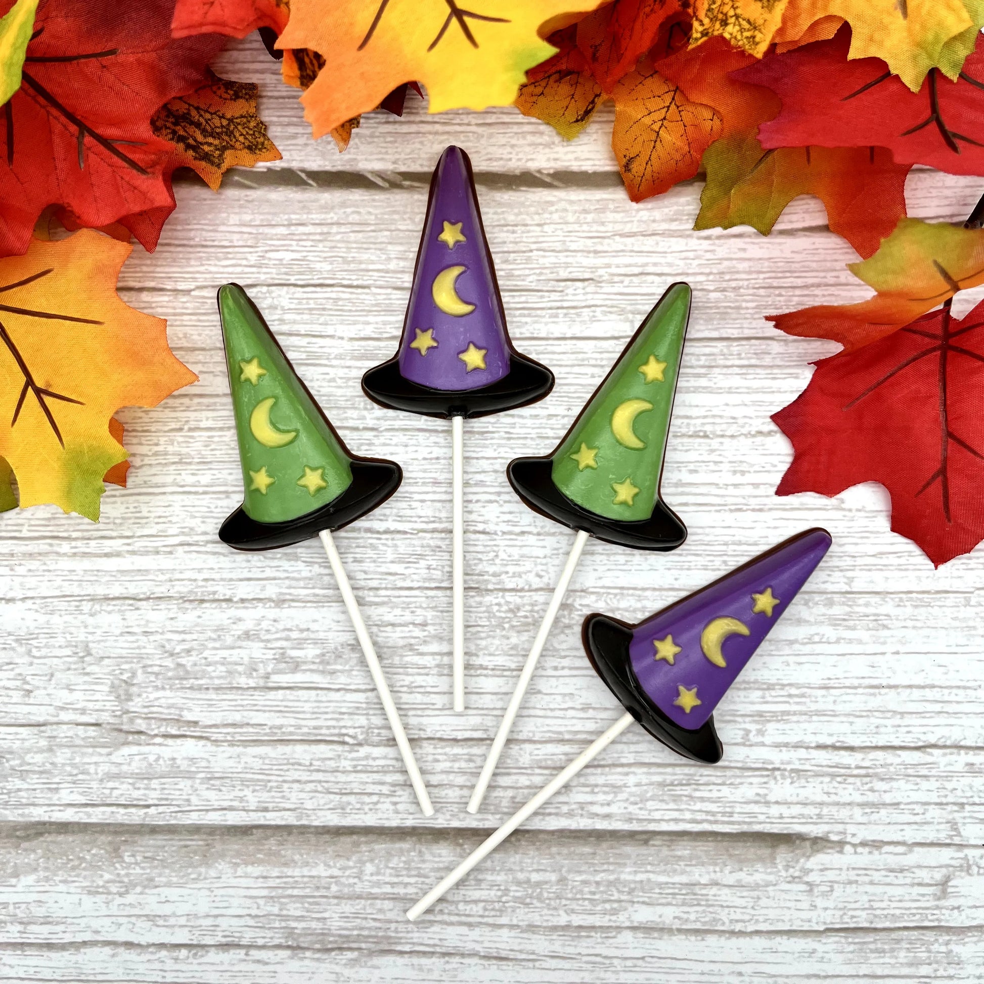 Black, purple and green witch hat suckers with yellow stars and moon; all made from chocolate. 