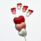 Three hearts stacked on top of each other, on a stick as a chocolate sucker. Variations of white, pink and red on each.