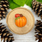 Fall-themed chocolate of a seasonal orange pumpkin with a green tendril, paired with an autumn oak leaf.