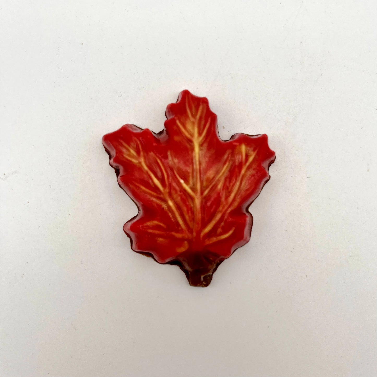 Realistic chocolate maple leaf, hand-painted in a blend of yellow, orange and red fall seasonal colours.