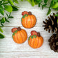 Fall-themed chocolates of seasonal orange pumpkins with green tendrils, decorated with an autumn oak leaf.