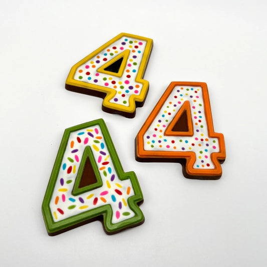 Three colourful number '4' chocolates, hand-painted with multi-colour dots and sprinkles. Displayed on a white background.